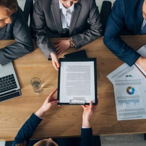 overhead-view-of-employee-holding-resume-near-recruiters-at-table.jpg